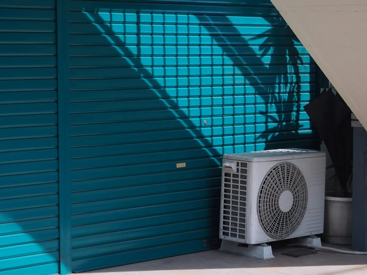 Outdoor air conditioning condenser beside a home